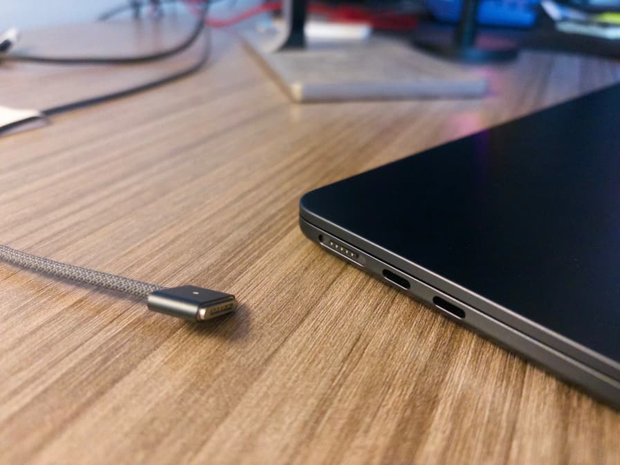 Close up of a MagSafe cable next to a MacBook Air's MagSafe port